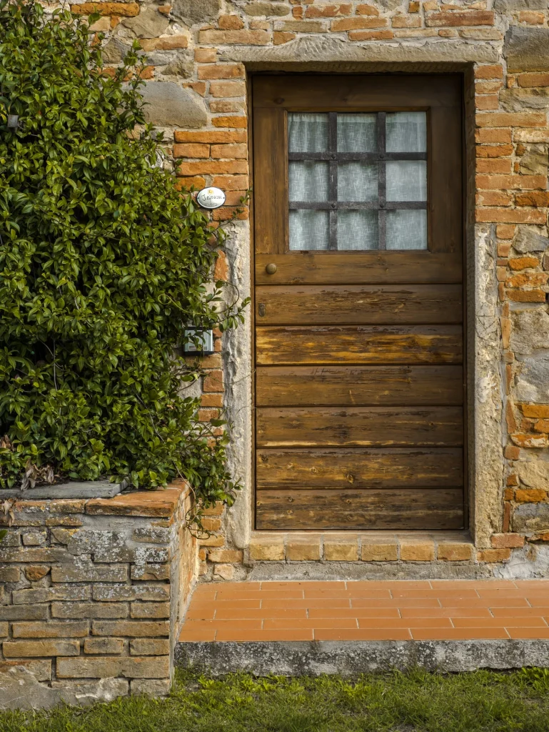 Portone in legno e muro in mattoni di un agriturismo in Toscana