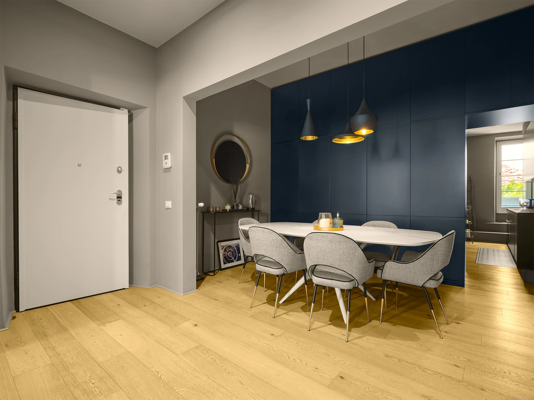 Zona pranzo con parete blu e parquet in un appartamento moderno