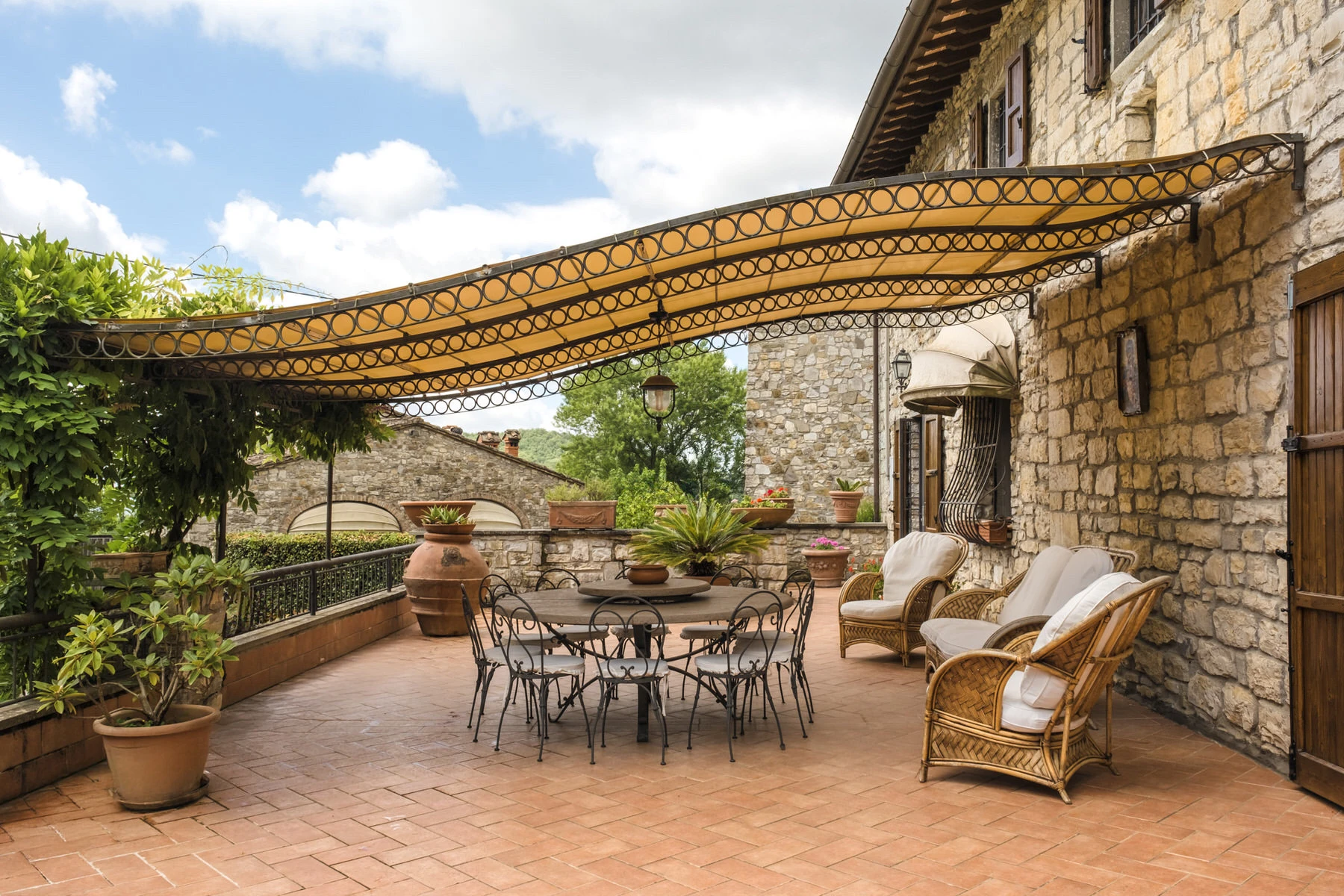 Terrazza con pergolato e arredi da esterno di un casale in pietra