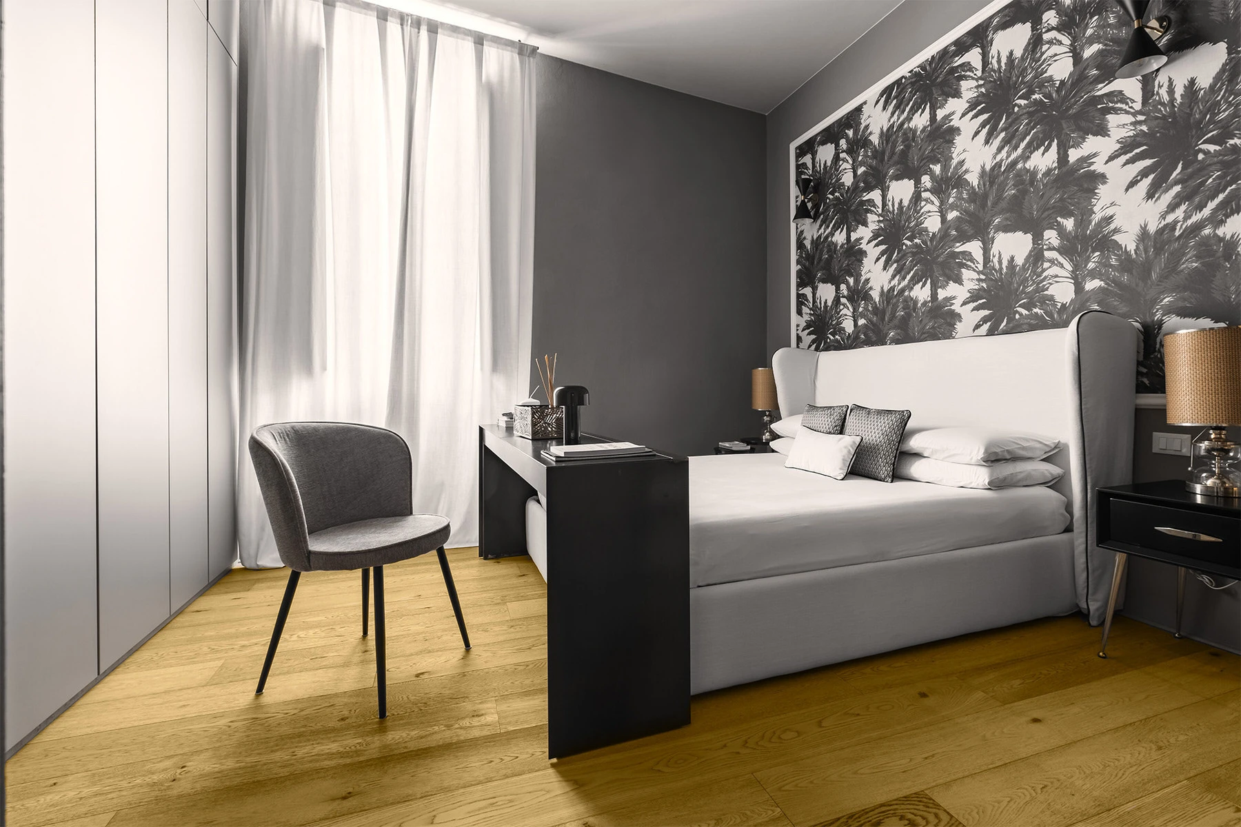 Camera da letto con carta da parati floreale e poltrona grigia