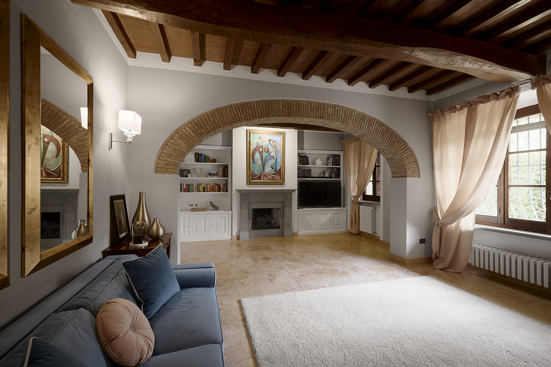 Soggiorno rustico con arco in pietra e travi a vista a Cantagallo
